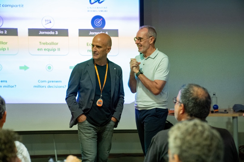 Dos formadores de Geyser presentando el programa de jornadas ante un grupo.